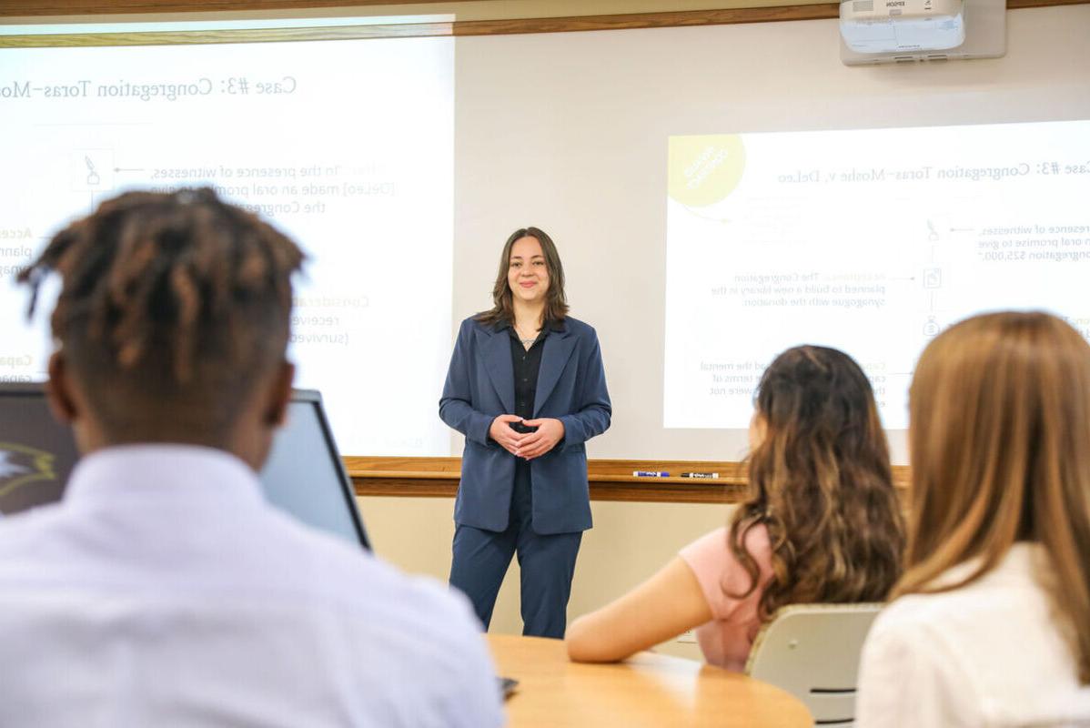 A female student presents to classmates as part of a business class